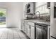 Updated kitchen with gray cabinets, stylish tile backsplash, and stainless steel appliances, enhancing functionality and style at 1515 Randall Rd, Indianapolis, IN 46240