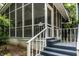 Close-up of screened-in porch with white railings and blue steps at 1515 Randall Rd, Indianapolis, IN 46240