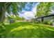 Lush backyard with a large grassy area, mature trees, and an outbuilding for extra storage at 1605 Westlane Rd, Indianapolis, IN 46260