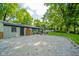 View of the backyard featuring a gravel area and mature trees that provide plenty of shade at 1605 Westlane Rd, Indianapolis, IN 46260