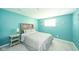 Comfortable bedroom with bright blue accent wall and wooden headboard at 1605 Westlane Rd, Indianapolis, IN 46260