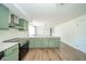Updated kitchen with green cabinets, modern appliances and granite countertops offers plenty of space at 1605 Westlane Rd, Indianapolis, IN 46260