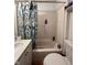 Clean bathroom features a shower-tub combo with a fern-themed curtain and updated fixtures at 1728 N Somerset Ave, Indianapolis, IN 46222