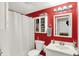 Bathroom featuring a white vanity, toilet, shower/tub with red accent wall, and recessed lighting at 1759 Michele Ln, Greenwood, IN 46142