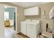 Laundry room with washer, dryer, overhead cabinets, and a glimpse into the kitchen at 1759 Michele Ln, Greenwood, IN 46142