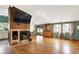 Sunlit living room with hardwood floors, a cozy fireplace, vaulted ceilings, and sliding door access to patio at 1759 Michele Ln, Greenwood, IN 46142