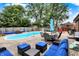 Backyard swimming pool with patio, comfortable seating, privacy fence, and mature shade trees at 1759 Michele Ln, Greenwood, IN 46142