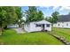 Aerial view of charming home with green yard, stairs to entry, and detached garage at 1933 Tallman Ave, Indianapolis, IN 46218