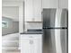 Stylish kitchen boasts stainless steel refrigerator, bright white cabinets, and durable countertops for a modern touch at 1933 Tallman Ave, Indianapolis, IN 46218