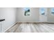 Bright living room featuring vinyl flooring, a large window, and a white door, offering a modern and inviting space at 1933 Tallman Ave, Indianapolis, IN 46218