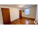 This empty bedroom offers hardwood floors, a window for natural light, and a built-in closet for ample storage space at 202 Collier St, Columbus, IN 47201