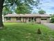 Ranch home with stone facade, attached garage, inviting front yard with landscaping, and a decorative wreath at 202 Collier St, Columbus, IN 47201