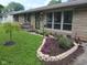 Charming home with stone facade and colorful landscaping, including flower beds and a decorative wreath at 202 Collier St, Columbus, IN 47201
