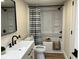 Modern bathroom with black hardware and a white vanity, shower-tub combo and striped shower curtain at 221 N 9Th St, Elwood, IN 46036