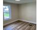 Bright bedroom with hardwood flooring, white trim, a window, and neutral paint color at 221 N 9Th St, Elwood, IN 46036