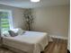 Serene bedroom featuring wood-look flooring, a bright window, and minimalist decor for a peaceful retreat at 221 N 9Th St, Elwood, IN 46036