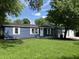 Charming blue home featuring white trim, lush lawn, and mature trees, offering great curb appeal at 221 N 9Th St, Elwood, IN 46036