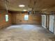 Spacious three car garage with overhead lighting, plywood walls, and ample room for parking and storage at 221 N 9Th St, Elwood, IN 46036