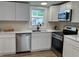 Modern kitchen equipped with stainless steel appliances, quartz countertops, and sleek white cabinets at 221 N 9Th St, Elwood, IN 46036
