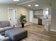 Bright, open living space featuring wood-look floors, leading into a modern kitchen with white cabinetry at 221 N 9Th St, Elwood, IN 46036