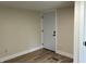 Neutral room with wood floors, showing a simple white door, neutral walls and white trim at 221 N 9Th St, Elwood, IN 46036