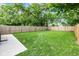 Well-maintained backyard with green grass, a wooden fence, and a concrete patio for outdoor entertaining at 3035 Guilford Ave, Indianapolis, IN 46205
