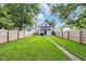 Spacious backyard with a lush lawn, framed by a wooden fence and mature trees, perfect for recreation at 3035 Guilford Ave, Indianapolis, IN 46205