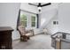 Cozy bedroom with a ceiling fan, a rocking chair, and ample natural light from two large windows at 3035 Guilford Ave, Indianapolis, IN 46205