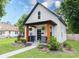Charming renovated bungalow featuring black trim, bright orange porch supports, and fresh landscaping at 3035 Guilford Ave, Indianapolis, IN 46205