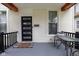 Inviting front porch with a modern front door, outdoor seating area, and neutral decor at 3035 Guilford Ave, Indianapolis, IN 46205