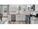 Updated kitchen boasts white cabinets, modern appliances, granite countertops, and hardwood floors at 3035 Guilford Ave, Indianapolis, IN 46205