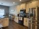 Well-lit kitchen features stainless steel refrigerator and black stove with white cabinets and dark countertops at 3072 W Glacier Dr, Monrovia, IN 46157