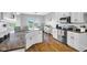 Bright kitchen boasts white cabinetry, modern appliances, and beautiful wood floors at 3072 W Glacier Dr, Monrovia, IN 46157