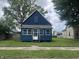 Charming blue home with a well-maintained front yard, inviting curb appeal and mature trees at 3127 E Lynn St, Anderson, IN 46016