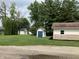 View of backyard with several storage buildings with siding matching house at 321 S 23Rd St, Elwood, IN 46036