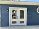 Exterior door with glass, set in navy blue painted siding at 321 S 23Rd St, Elwood, IN 46036