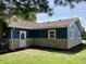 View of the home's exterior highlighting the back entrance, windows, and well-kept landscaping at 321 S 23Rd St, Elwood, IN 46036
