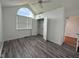 Bright bedroom with arch window, ceiling fan, closet, and gray wood-look flooring at 3327 Boxwood Dr, Indianapolis, IN 46227