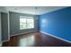 Bedroom with a blue accent wall, large window, and modern light fixture at 3610 Homestead Pl, Plainfield, IN 46168