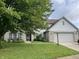 Charming two-story home with a well-manicured lawn, attached two-car garage, and lush landscaping at 3610 Homestead Pl, Plainfield, IN 46168