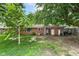 Brick house backyard with trees, foliage, grass, and patio area at 3636 Oakwood Dr, Anderson, IN 46011
