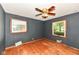 Bedroom featuring hardwood floors, two windows, ceiling fan, and air vent at 3636 Oakwood Dr, Anderson, IN 46011