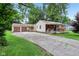 The front exterior has a large concrete driveway with a covered front porch at 3921 S Lasalle St, Indianapolis, IN 46237