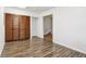 Bright living room features a large closet with wood doors and a warm toned, wood-look laminate floor at 3921 S Lasalle St, Indianapolis, IN 46237
