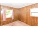 Wood-paneled bedroom featuring a window and warm wall-mounted lighting at 3965 Alsace Pl, Indianapolis, IN 46226