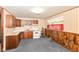 Functional kitchen with wooden cabinets, wallpaper, and essential appliances at 3965 Alsace Pl, Indianapolis, IN 46226