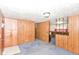 Cozy living area with paneled walls, carpet, and entry to kitchen or dining at 3965 Alsace Pl, Indianapolis, IN 46226