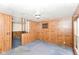 Open living space with paneled walls and carpet, next to split-level stair access at 3965 Alsace Pl, Indianapolis, IN 46226