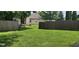 View of the backyard that features a well maintained lawn surrounded by a wooden fence for privacy at 403 Bagley Ln, Indianapolis, IN 46231