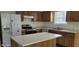 Functional kitchen with stainless steel appliances, wood cabinets, and white countertops, ready for cooking at 403 Bagley Ln, Indianapolis, IN 46231